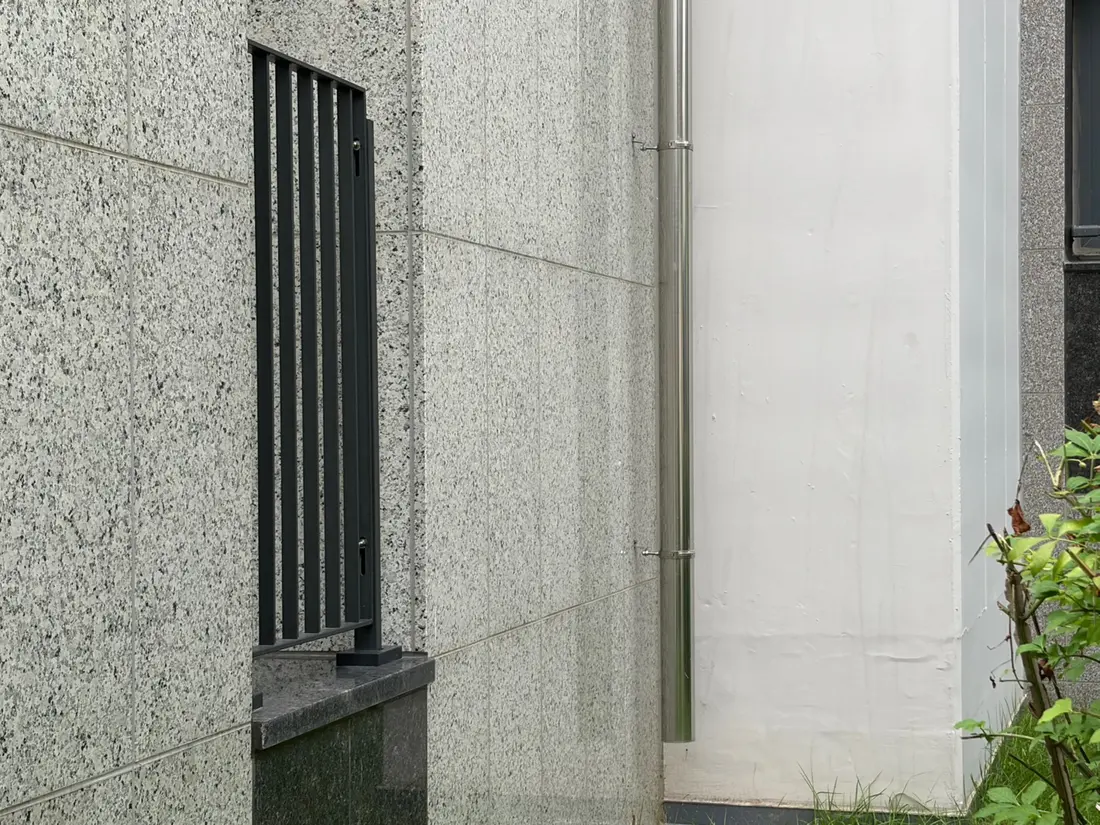 창 옆 석재 외벽에 설치된 우수관